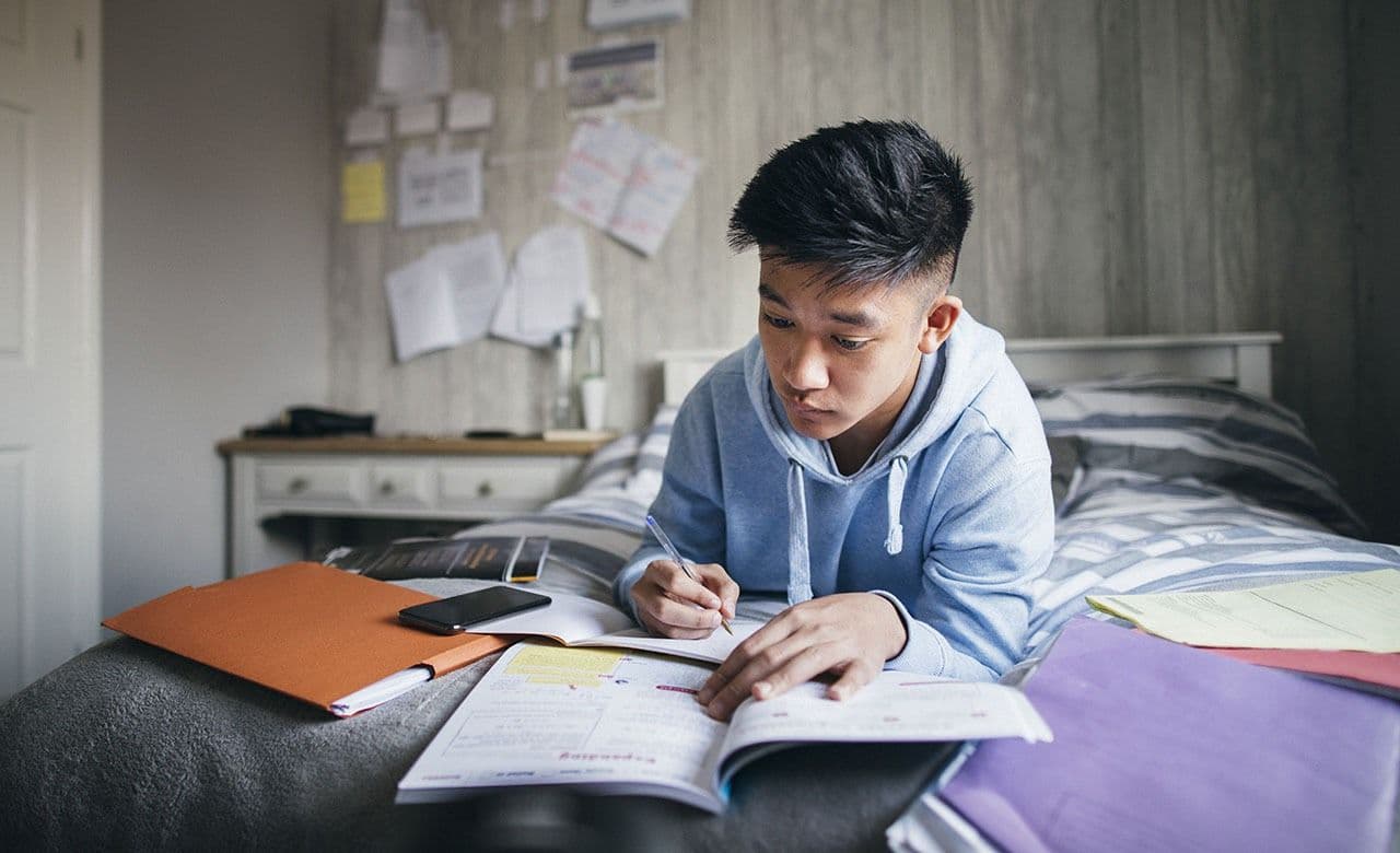 boy making notes - How To Study for Biology